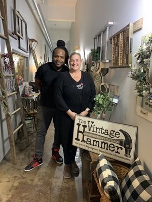 Owners of the Vintage Hammer posing with a sign